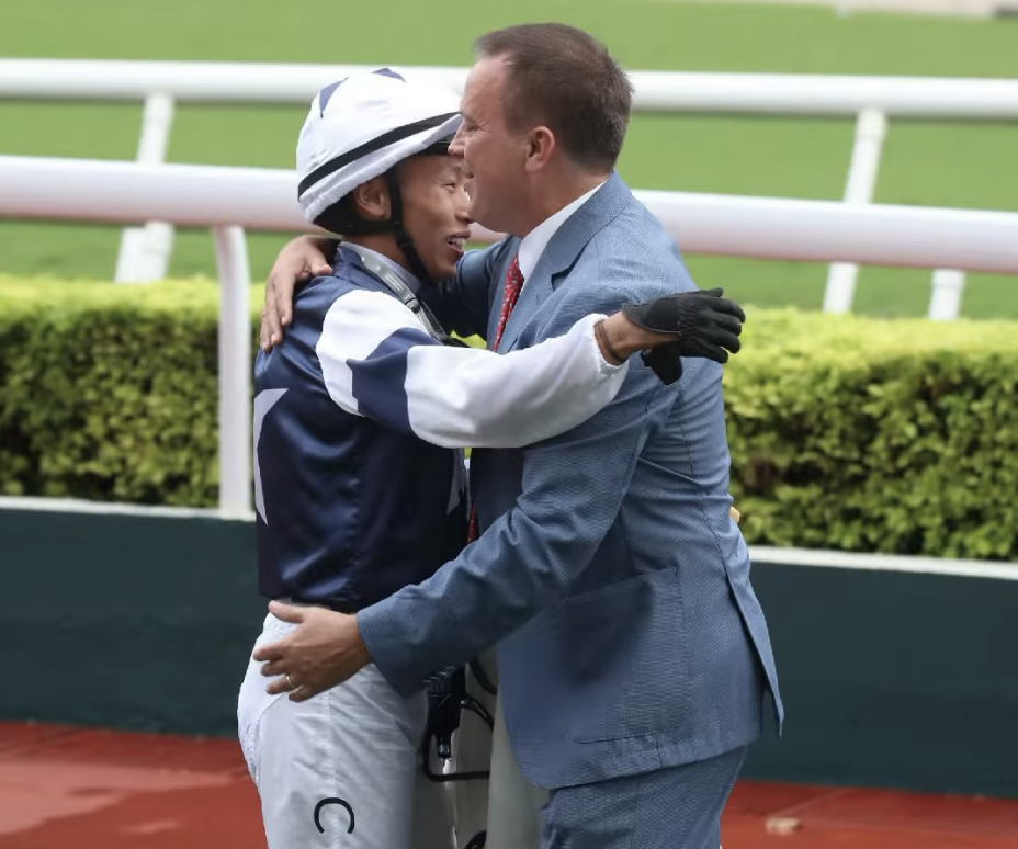 Vincent Ho et l'entraîneur Caspar Fownes après la victoire de The Heir, dimanche à Sha Tin.